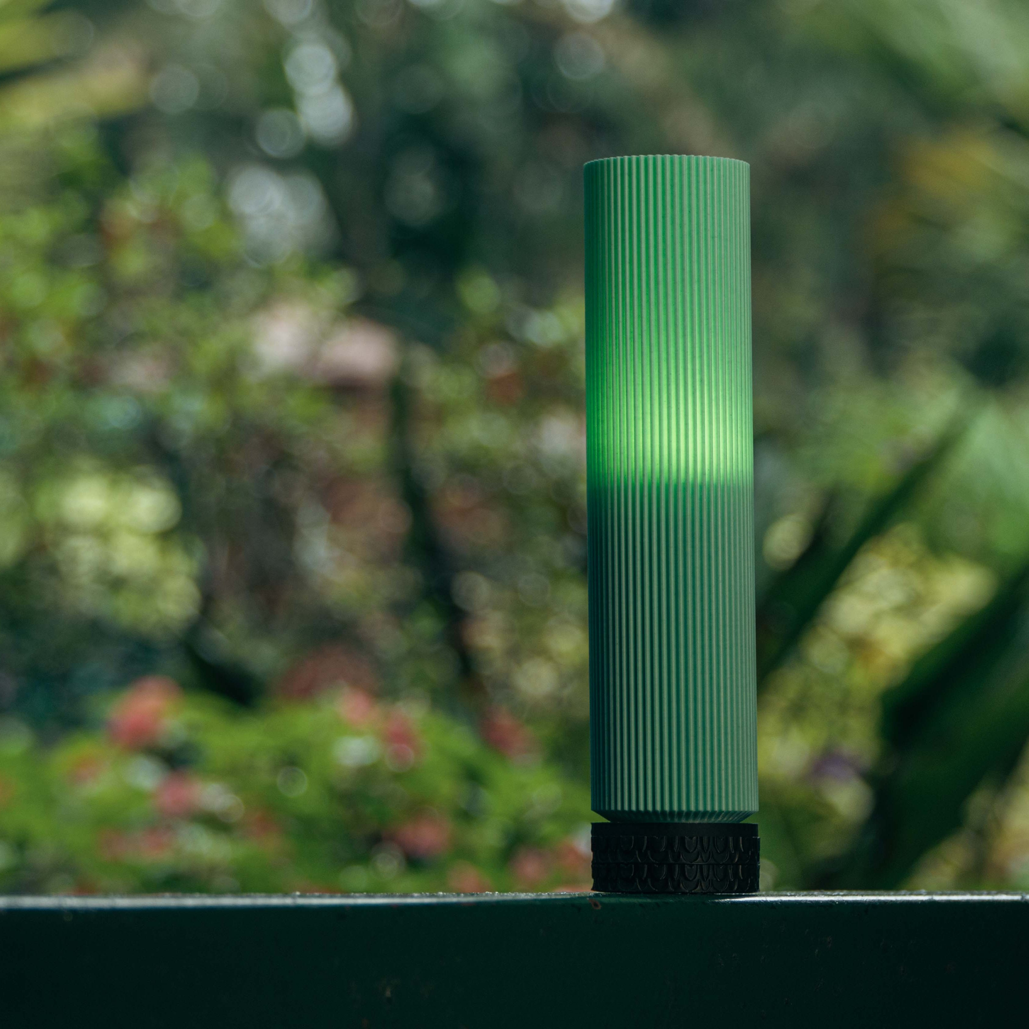 Green cylindrical object on a blurred natural background