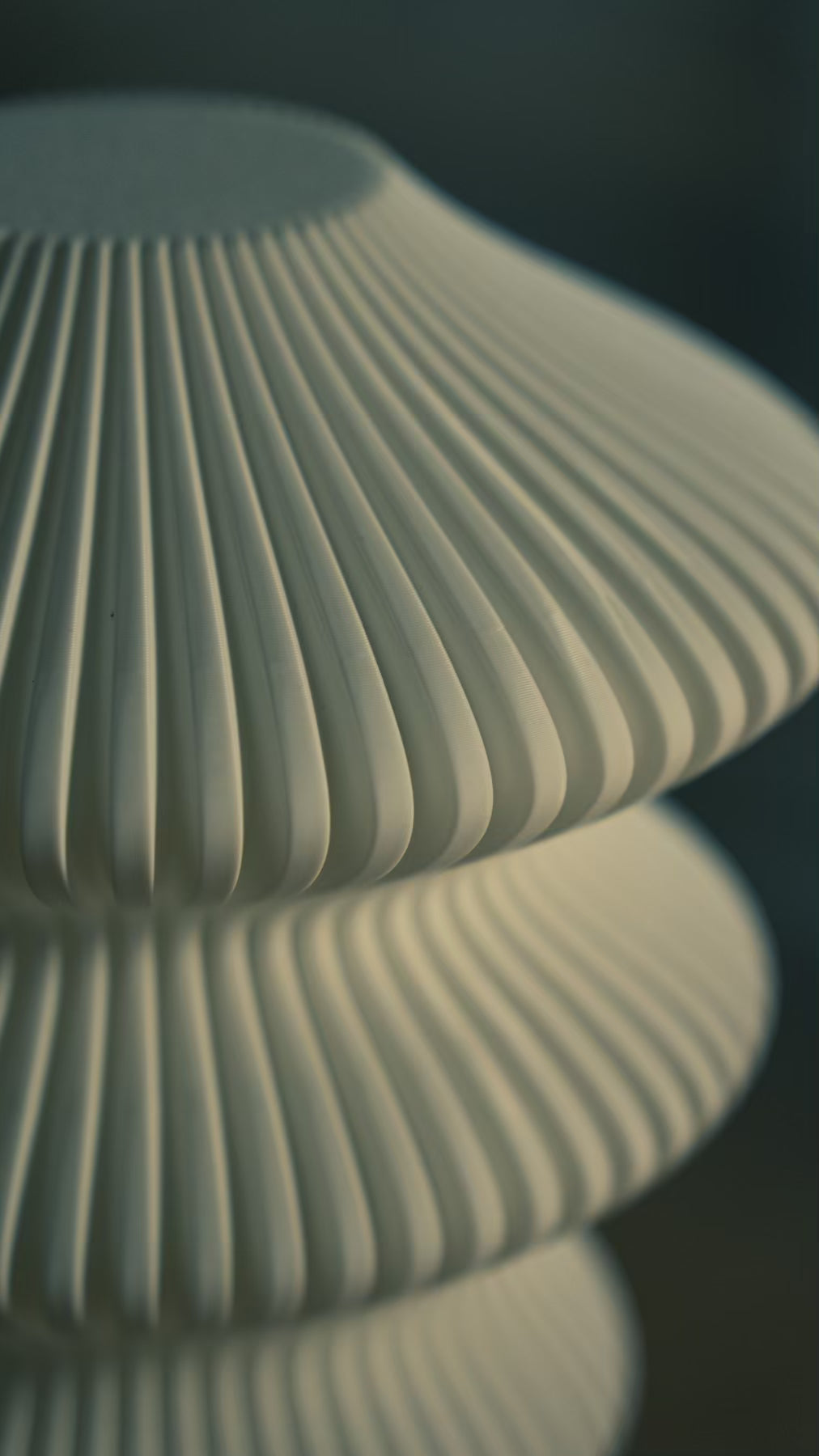 Surface detail of the Muvèlo Ruvaa Mono White rechargeable lamp showing its fine vertical ribs.