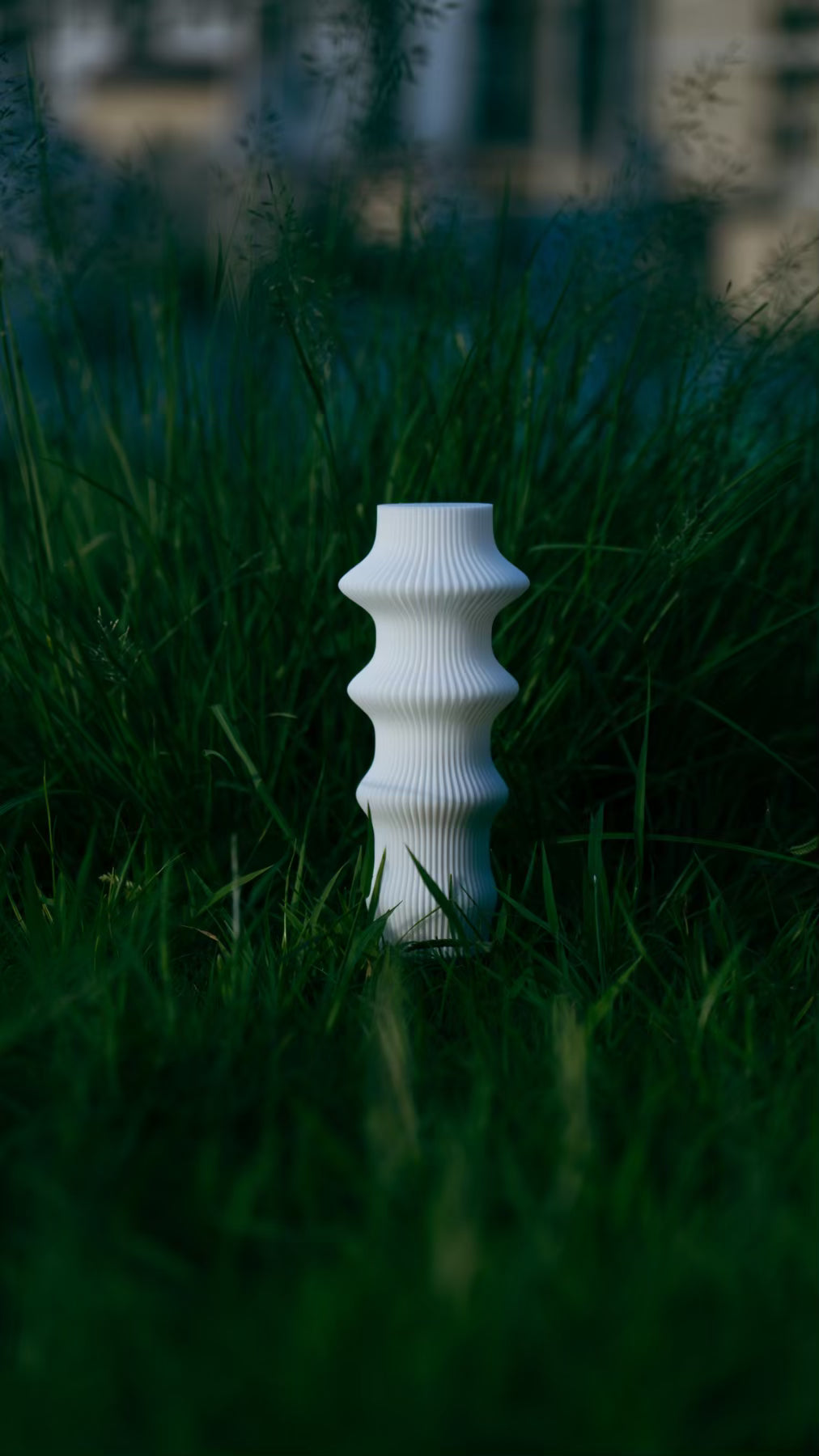 Front view of the Muvèlo Ruvaa White rechargeable table lamp and its flowing textured silhouette.