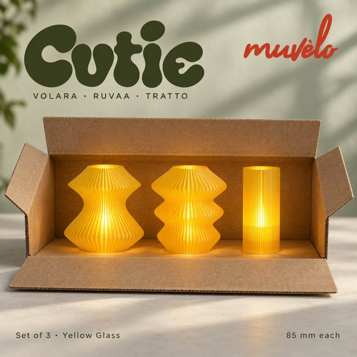 Three illuminated Yellow Glass Cutie lamps — Volara, Ruvaa, Tratto — displayed together in an open plain cardboard box.