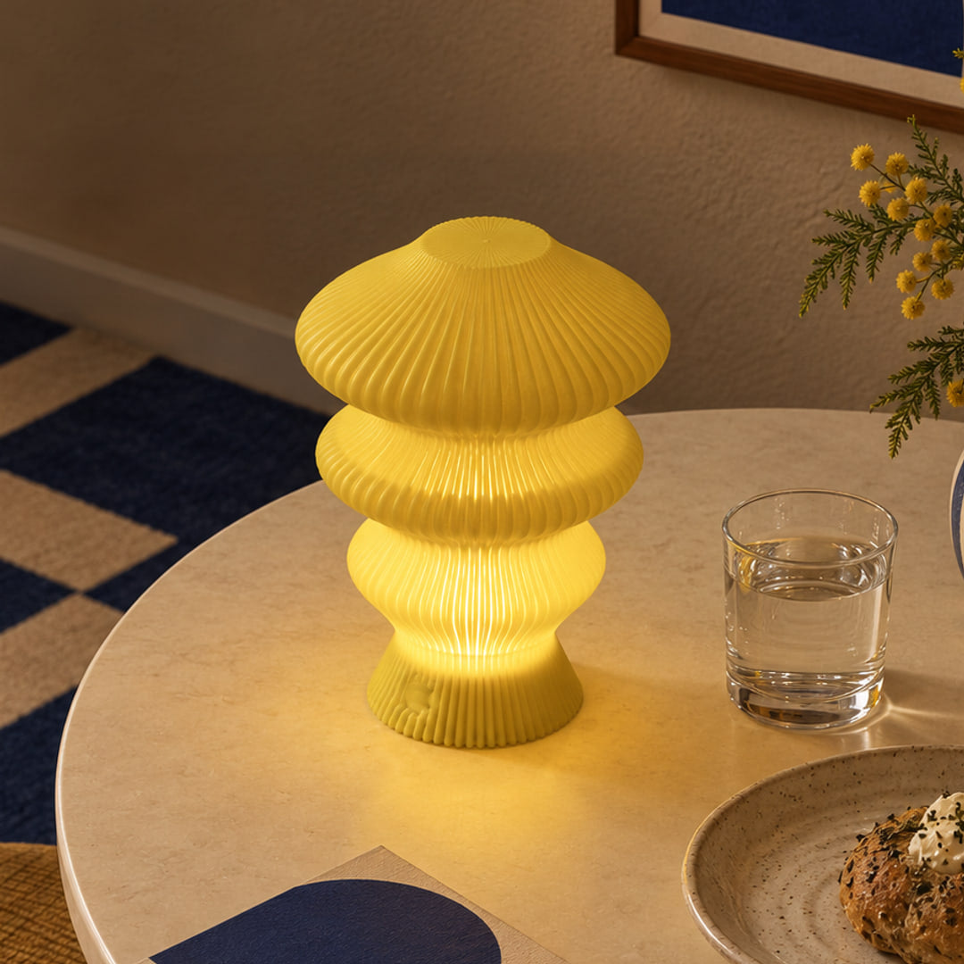 Muvèlo Ruvaa Mono Yellow table lamp glowing on a cream coffee table in a retro interior
