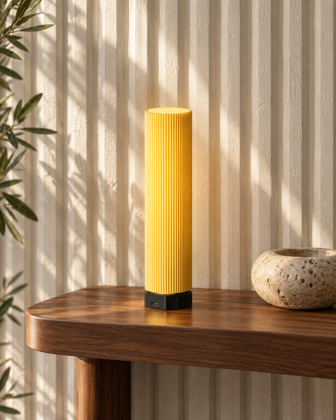 Tratto Butter portable table lamp on a walnut console against a fluted plaster wall