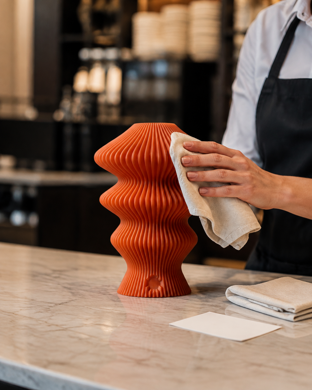 Restaurant staff hand cleaning an orange Muvèlo Ruvaa Mono with a dry cloth