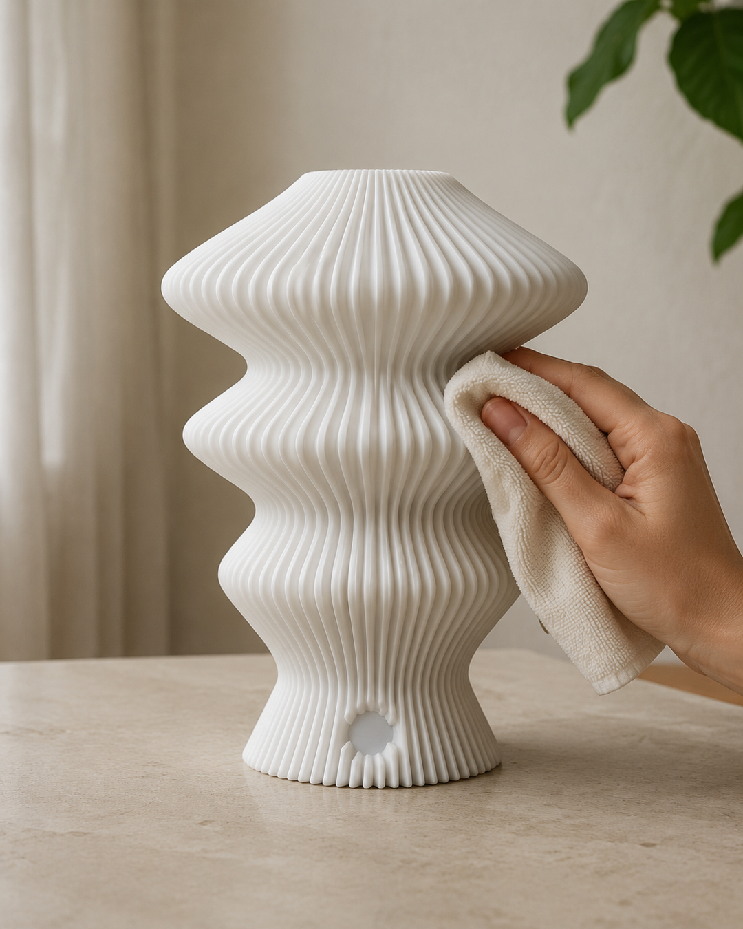 Hand cleaning the ribbed white Muvèlo Ruvaa Mono lamp with a soft dry cloth