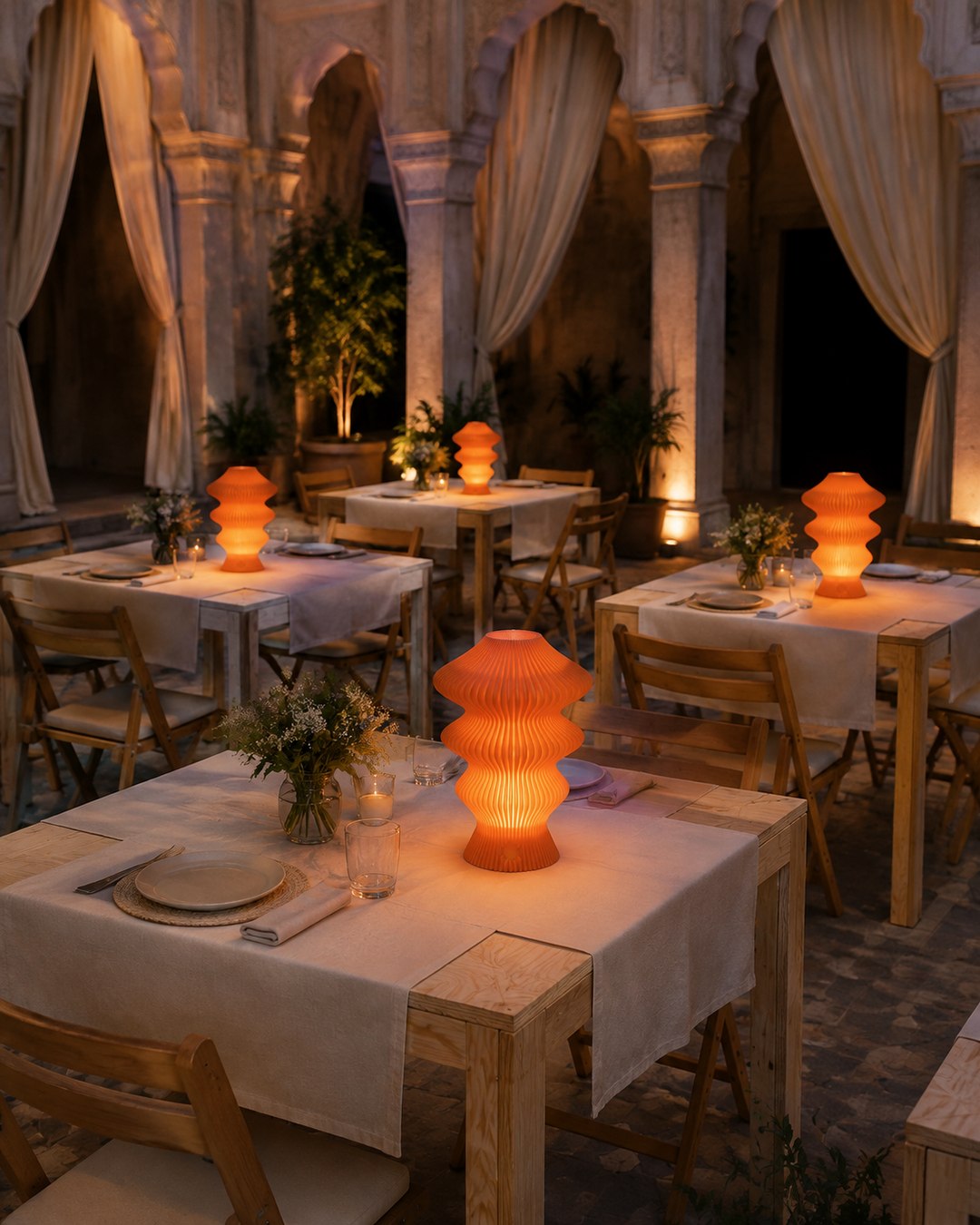 Orange Muvèlo Ruvaa Mono lamps glowing across covered pop-up dinner tables
