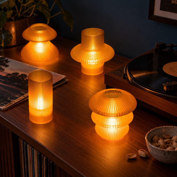 Orange Glass Cuties glowing around a record player and vinyl sleeve on a dark wooden console.