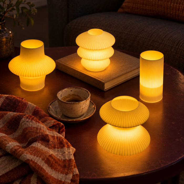 Four Butter Cuties glowing beside an espresso cup and clothbound book on a dark coffee table.