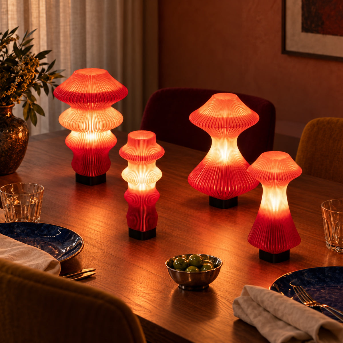Ruvaa and Volara Red Glass lamps in Ekkam and Max sizes lighting an oak dinner table with blue plates.