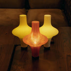 Three colorful lamps on a wooden surface with a blurred background