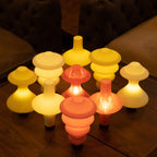 Set of colorful mushroom-shaped lights on a wooden surface.