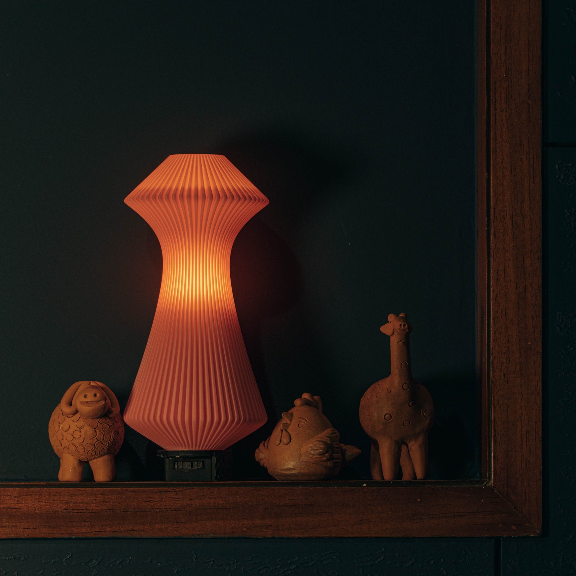 Decorative lamp with animal figurines on a dark background
