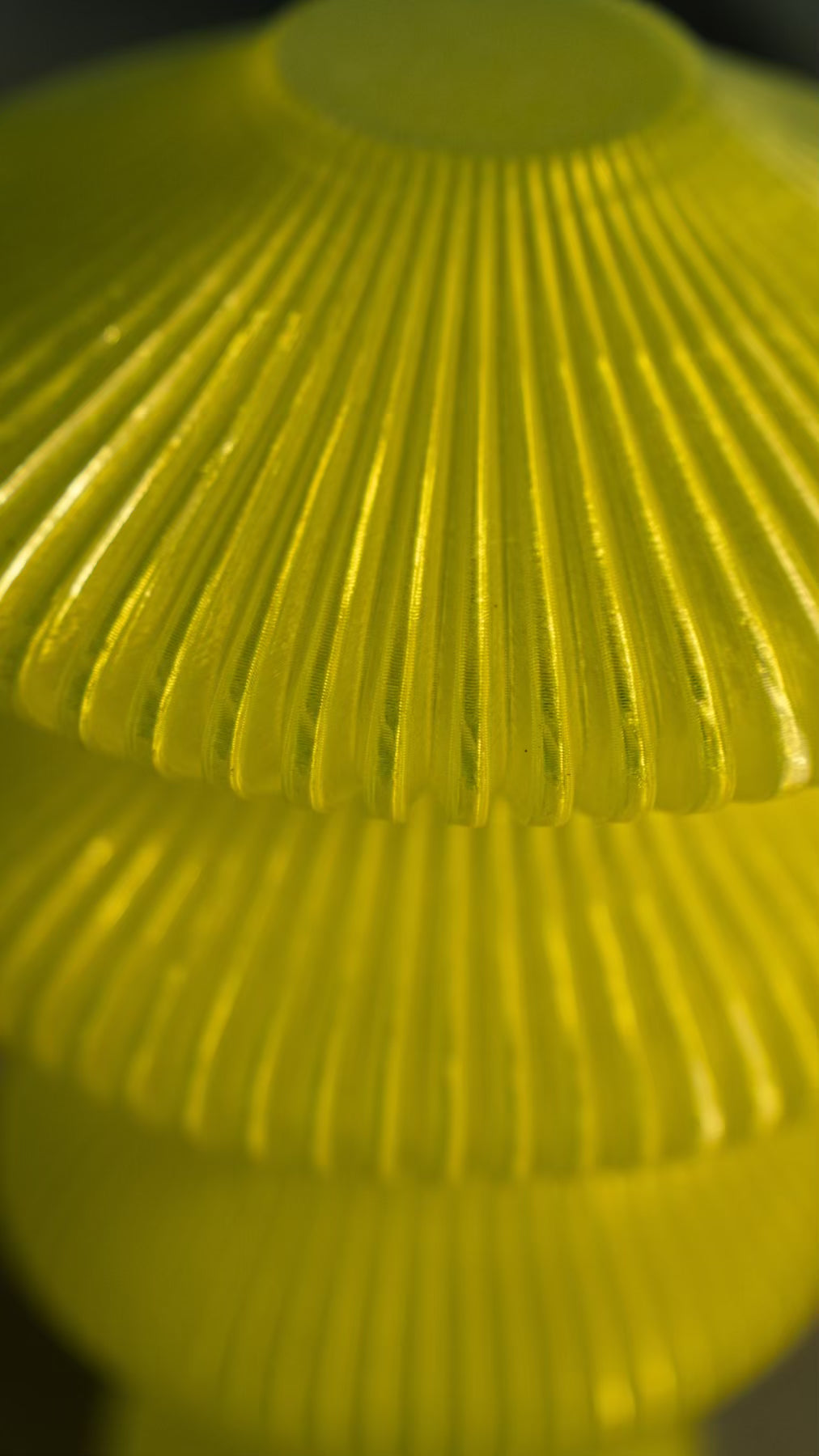 Close-up of the ribbed sculptural form of the Muvèlo Ruvaa Mono Yellow portable table lamp.