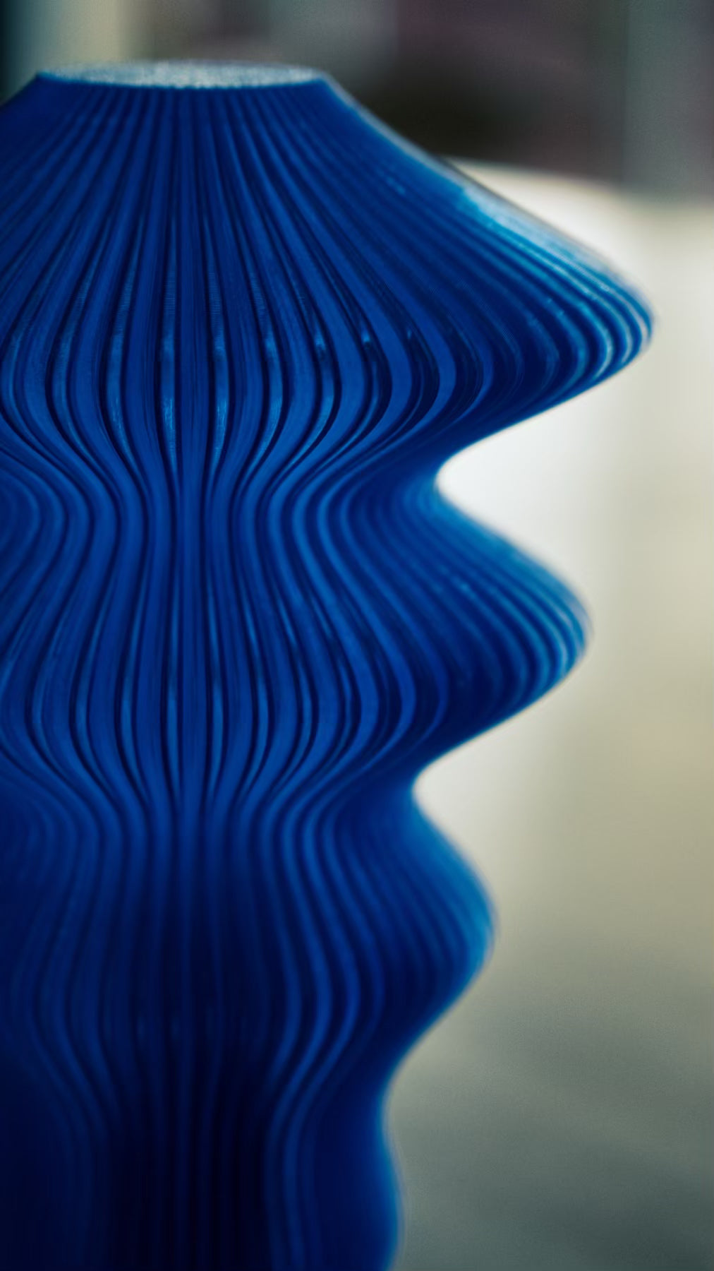 Front view of the Muvèlo Ruvaa Max Blue rechargeable table lamp and its flowing textured silhouette.