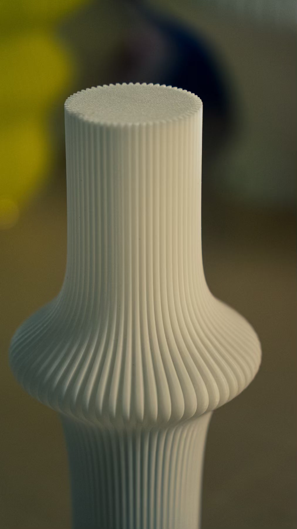 Sculptural profile of the Muvèlo Zeya White designer table lamp with a ribbed surface.