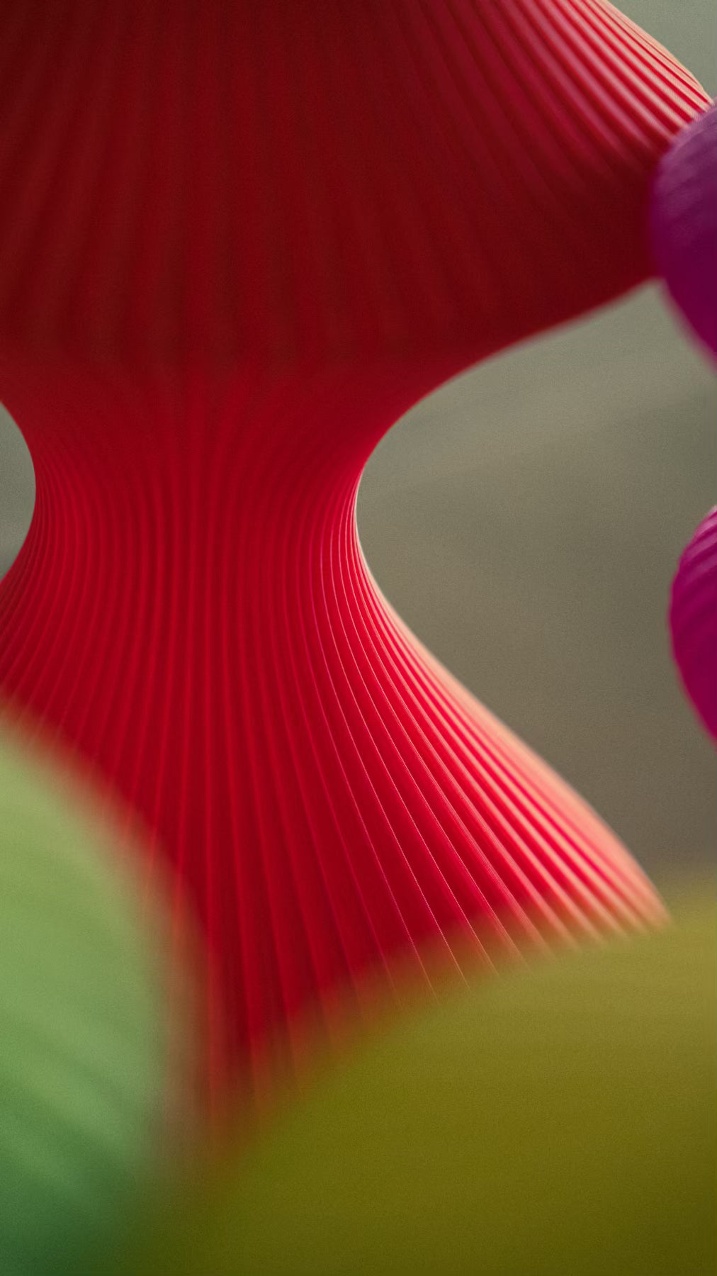 Close-up of the ribbed sculptural form of the Muvèlo Volara Max Red Glass portable table lamp.