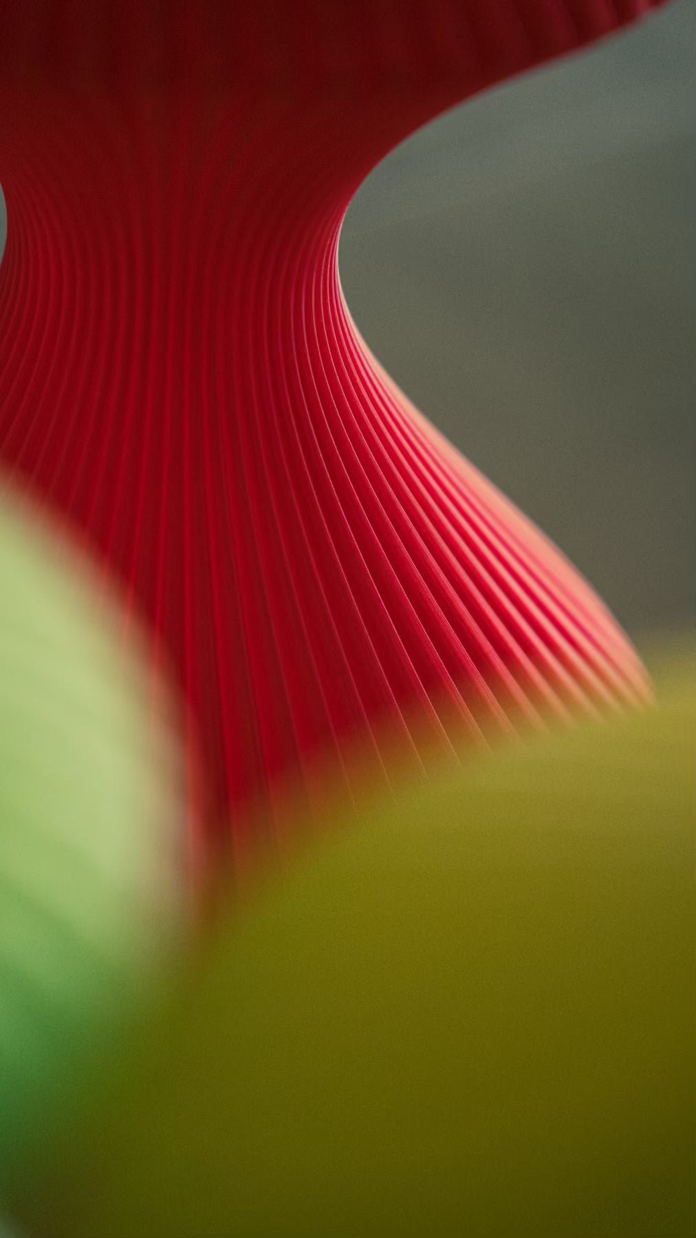 Macro view of the flowing ribs on the Muvèlo Volara Max Red Glass portable ambient lamp.