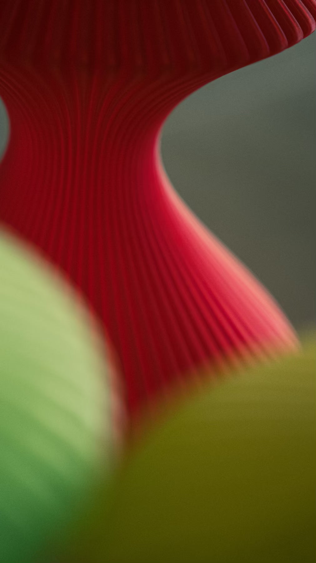 Surface detail of the Muvèlo Volara Max Red Glass rechargeable lamp showing its fine vertical ribs.