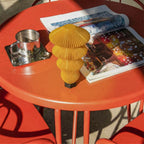 Yellow textured PORTABLE MODULAR TABLE LAMP on a red table with a magazine