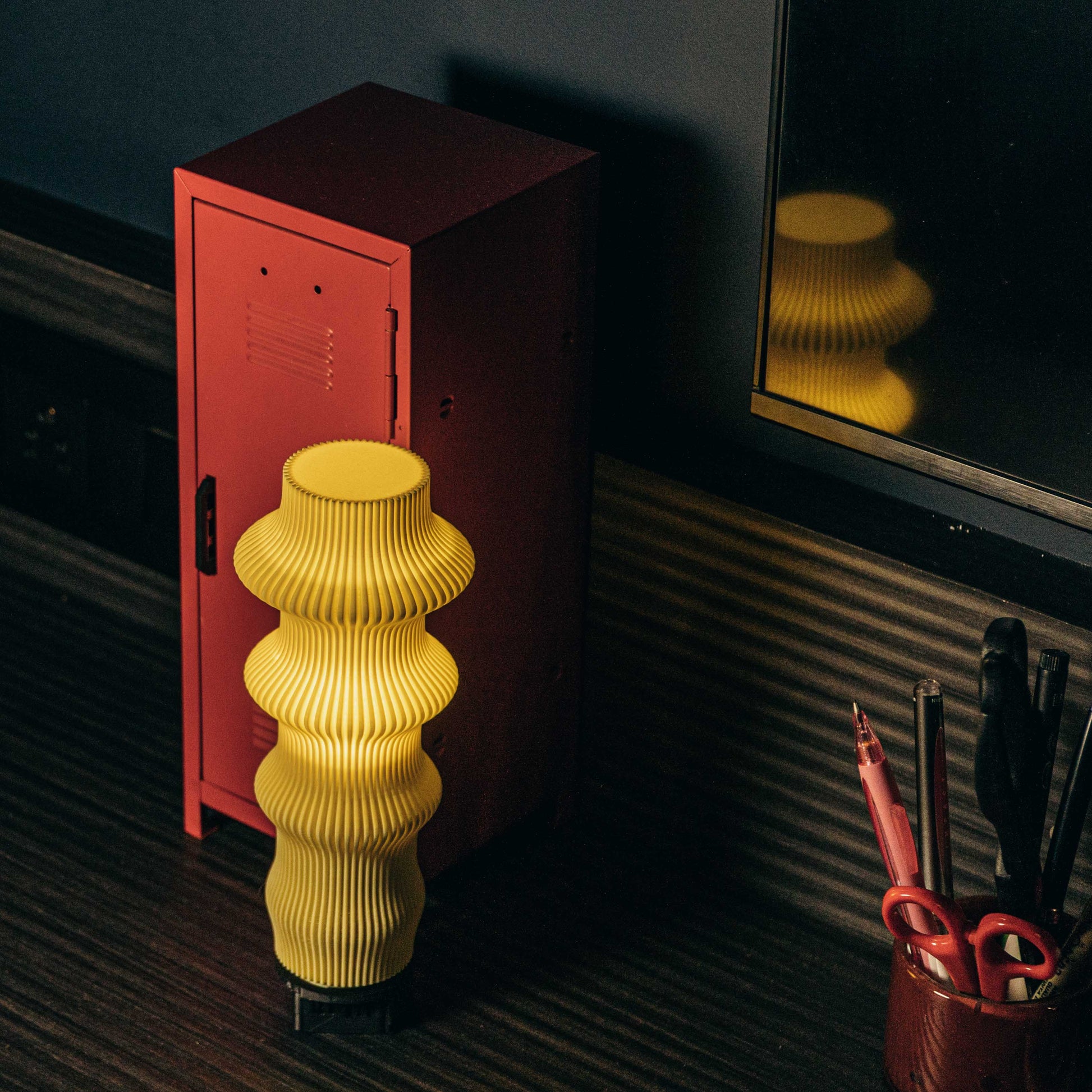 Yellow lamp on a desk with a laptop in the background