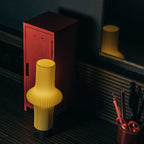 Yellow ribbed stool next to a red locker in a dimly lit room.