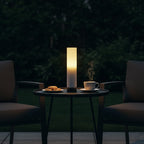 Candle on a table with a cup and cookies in a dark setting