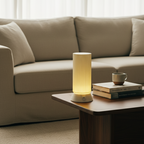 Lamp on a coffee table with books and a mug in a living room setting