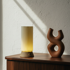Decorative lamp and sculpture on a wooden surface with a textured wall background
