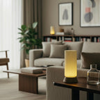 Modern living room with a lamp on a table and decor elements.