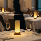 Dining table setup with wine glasses and a waiter in the background