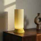 Yellow lamp on a wooden surface with a textured wall background
