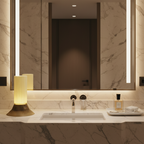 Luxurious bathroom vanity with a large illuminated mirror, marble countertop, and modern fixtures.
