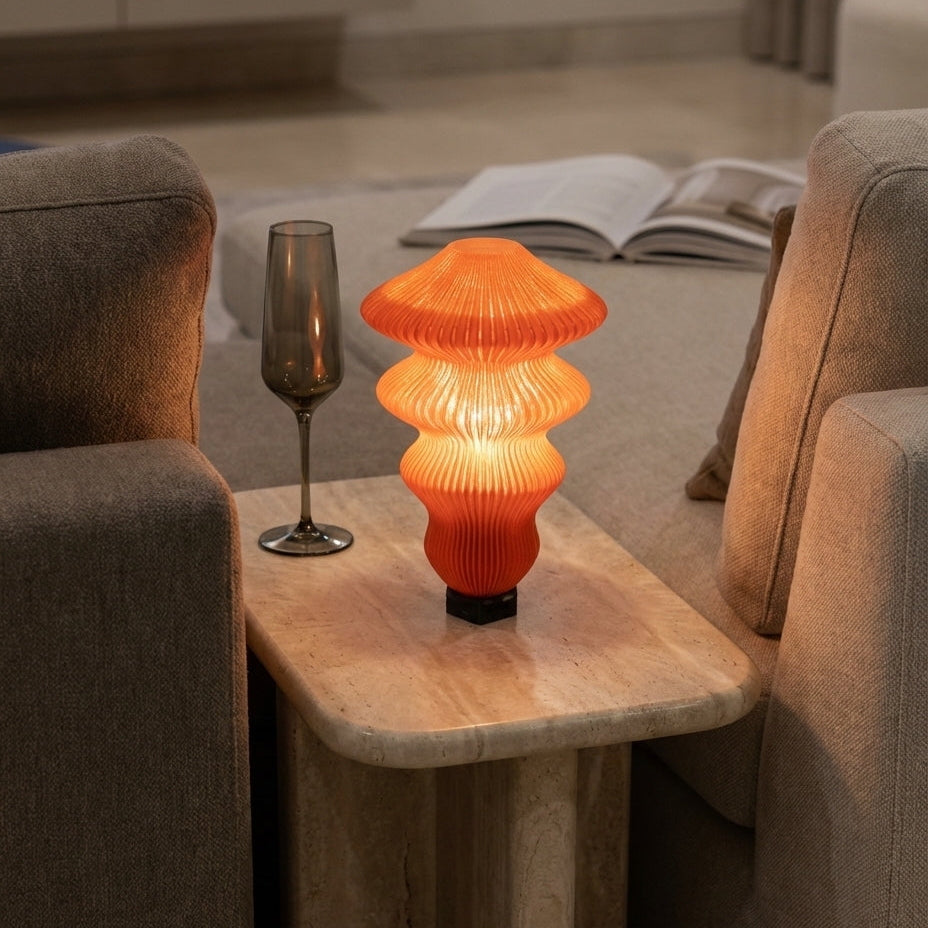 Orange table lamp on a wooden side table in a living room setting.
