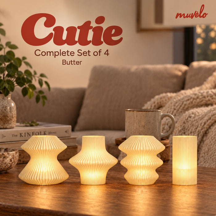 Cutie Butter Complete Set of 4 glowing on a wooden coffee table beside a cream sofa.