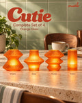 Cutie Orange Glass Complete Set of 4 glowing on a coffee corner: Volara, Zeya, Ruvaa and Tratto.