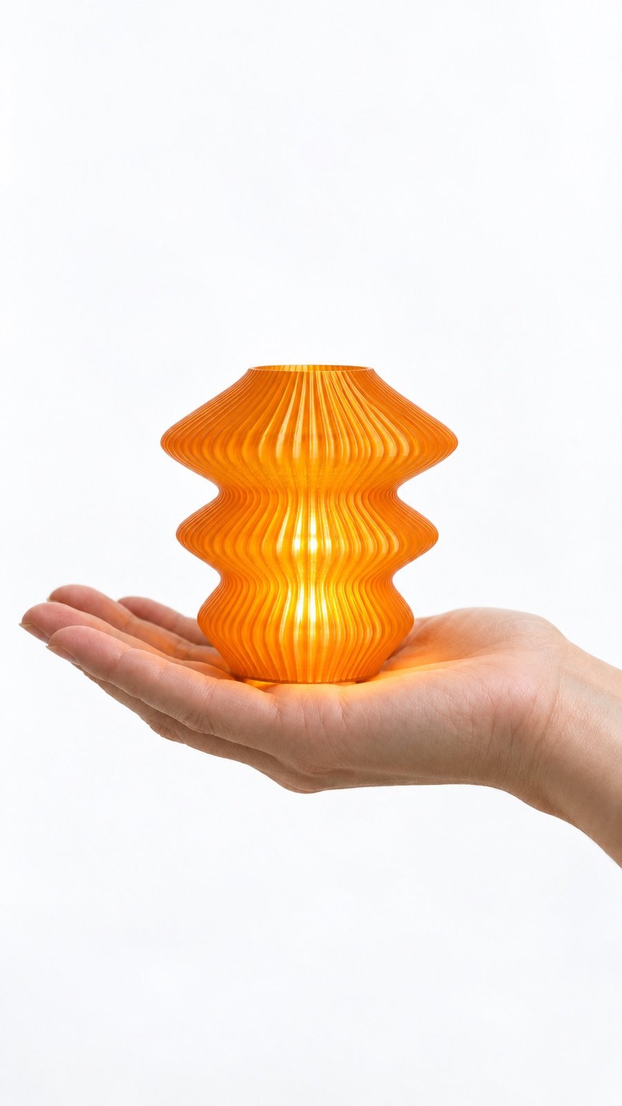 Orange Glass Ruvaa Cutie lamp resting on an open palm to show its miniature size.