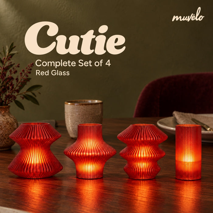 Cutie Red Glass Complete Set of 4 glowing on a wooden dining table: Volara, Zeya, Ruvaa and Tratto.