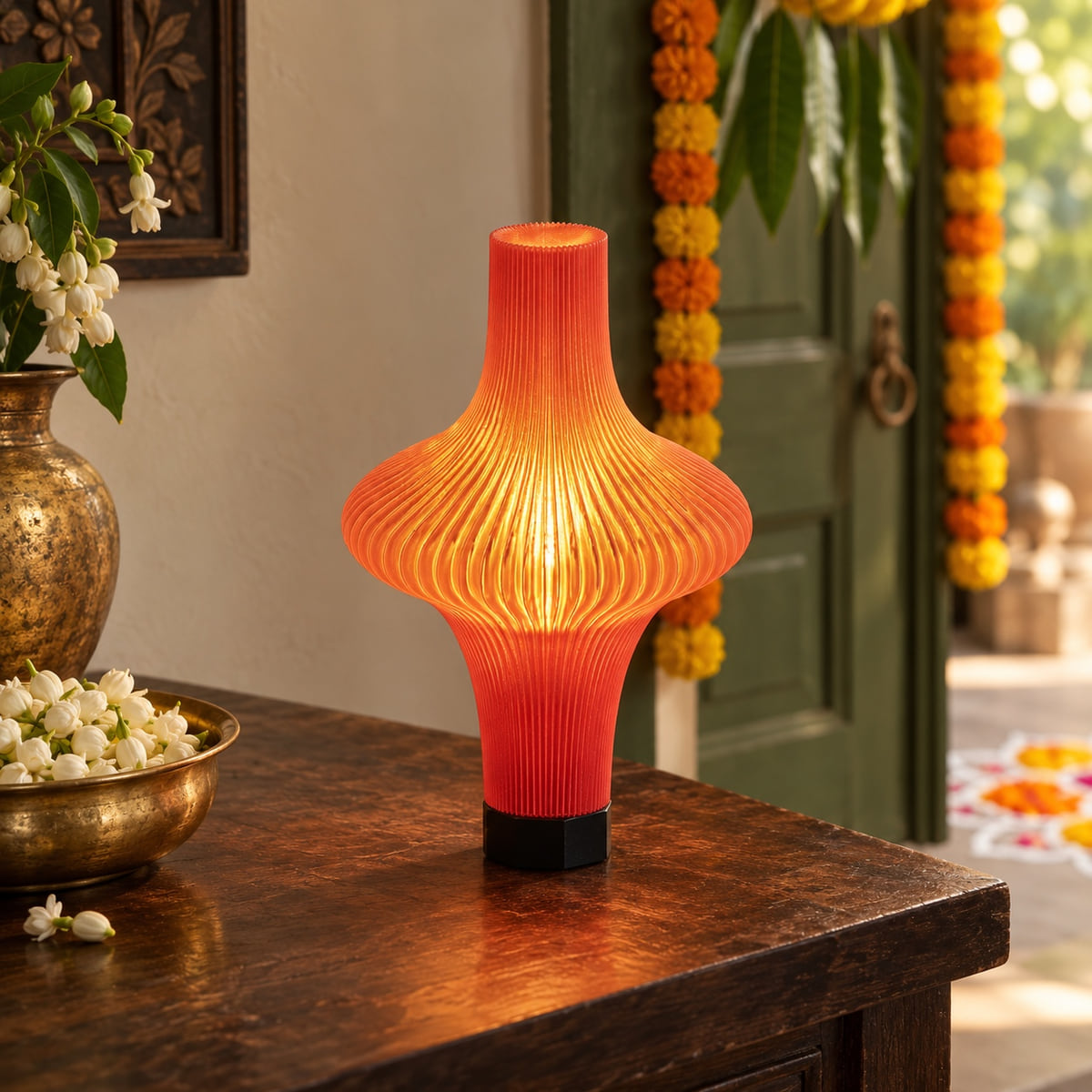 Zeya Max Red Glass lamp glowing on a surface in a Diwali setting with marigolds and festive home details.