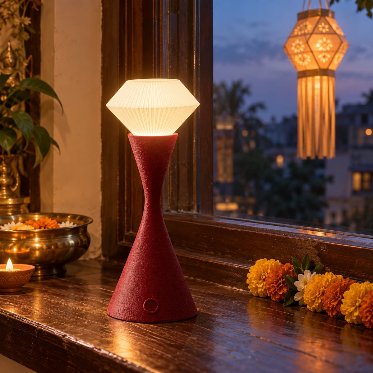 Maroon Vela beside a blue-hour window with a glowing Diwali kandil.