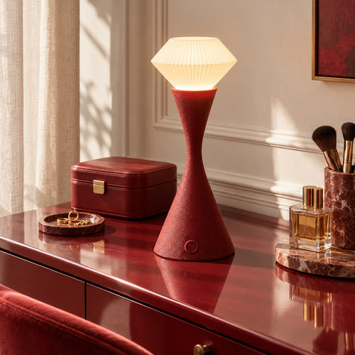 Muvèlo Vela Maroon table lamp glowing on a dressing table in soft daylight