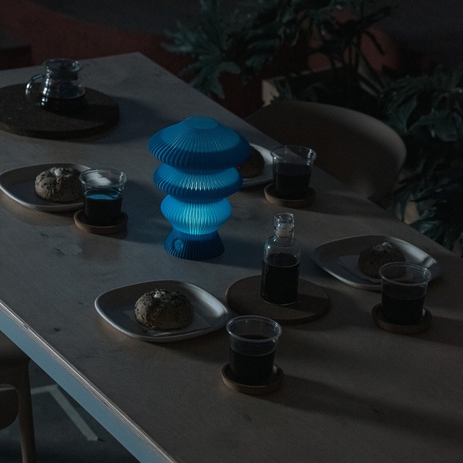 Blue Ruvaa Mono touch ambient lamp illuminated in a dark dining setting