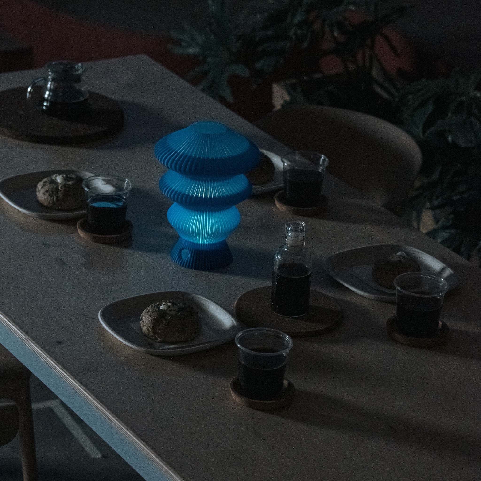 Blue Ruvaa Mono touch ambient lamp illuminated in a dark dining setting