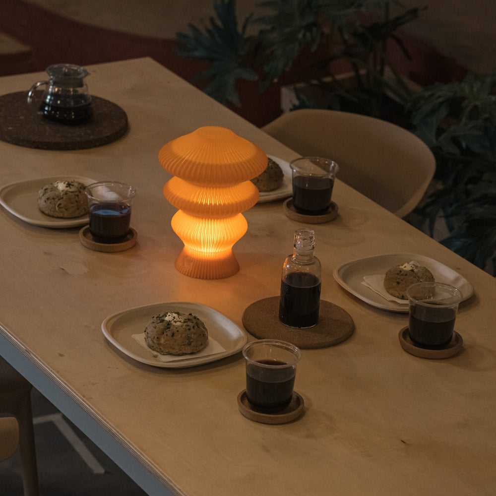 Orange Ruvaa Mono ambient table lamp glowing on a dining table