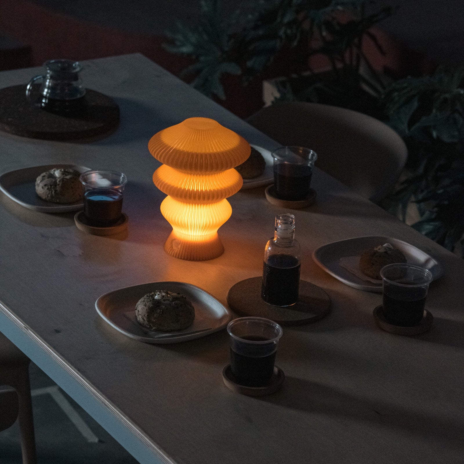 Orange Ruvaa Mono touch lamp illuminated in a dark dining setting