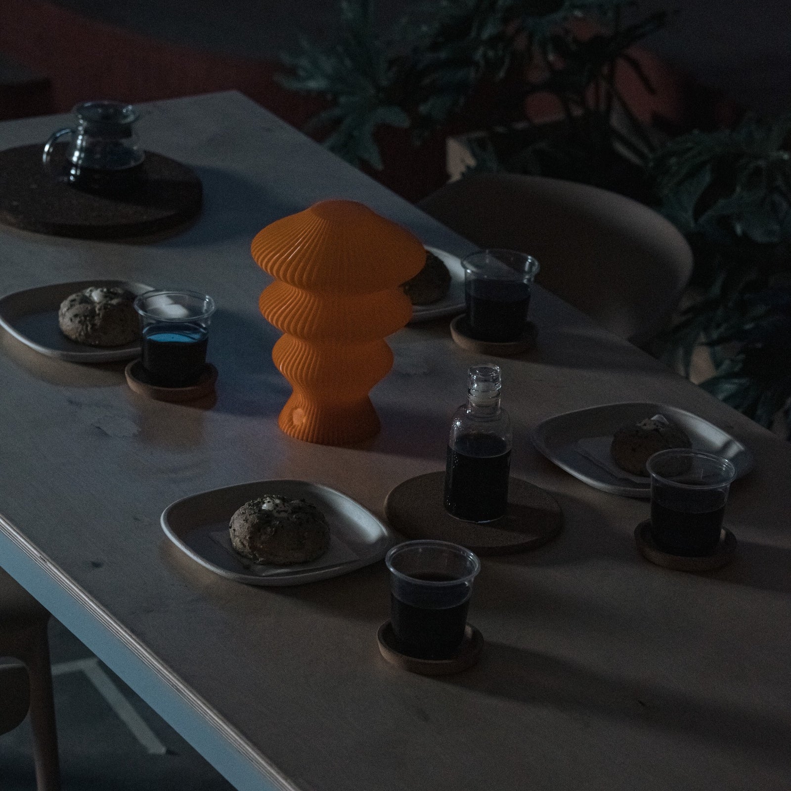 Orange Ruvaa Mono sculptural table lamp displayed in a low-light interior