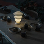 White Ruvaa Mono touch ambient lamp illuminated in a dark dining setting