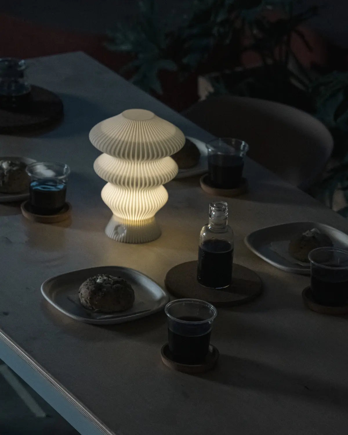 White Ruvaa Mono rechargeable table lamp glowing on a dining table