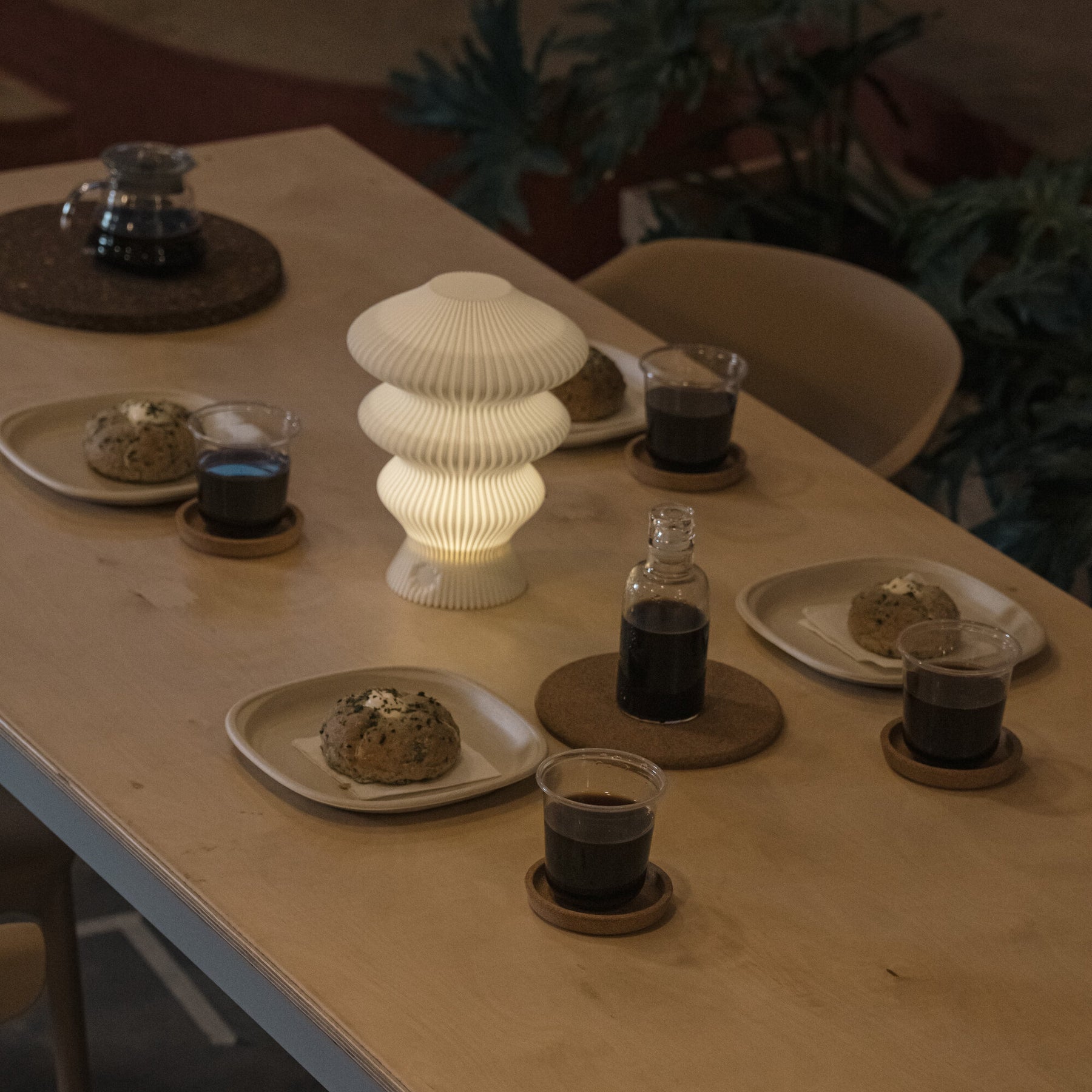 White Ruvaa Mono portable lamp creating warm ambient light on a table