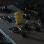 Yellow Ruvaa Mono sculptural table lamp displayed in a low-light interior