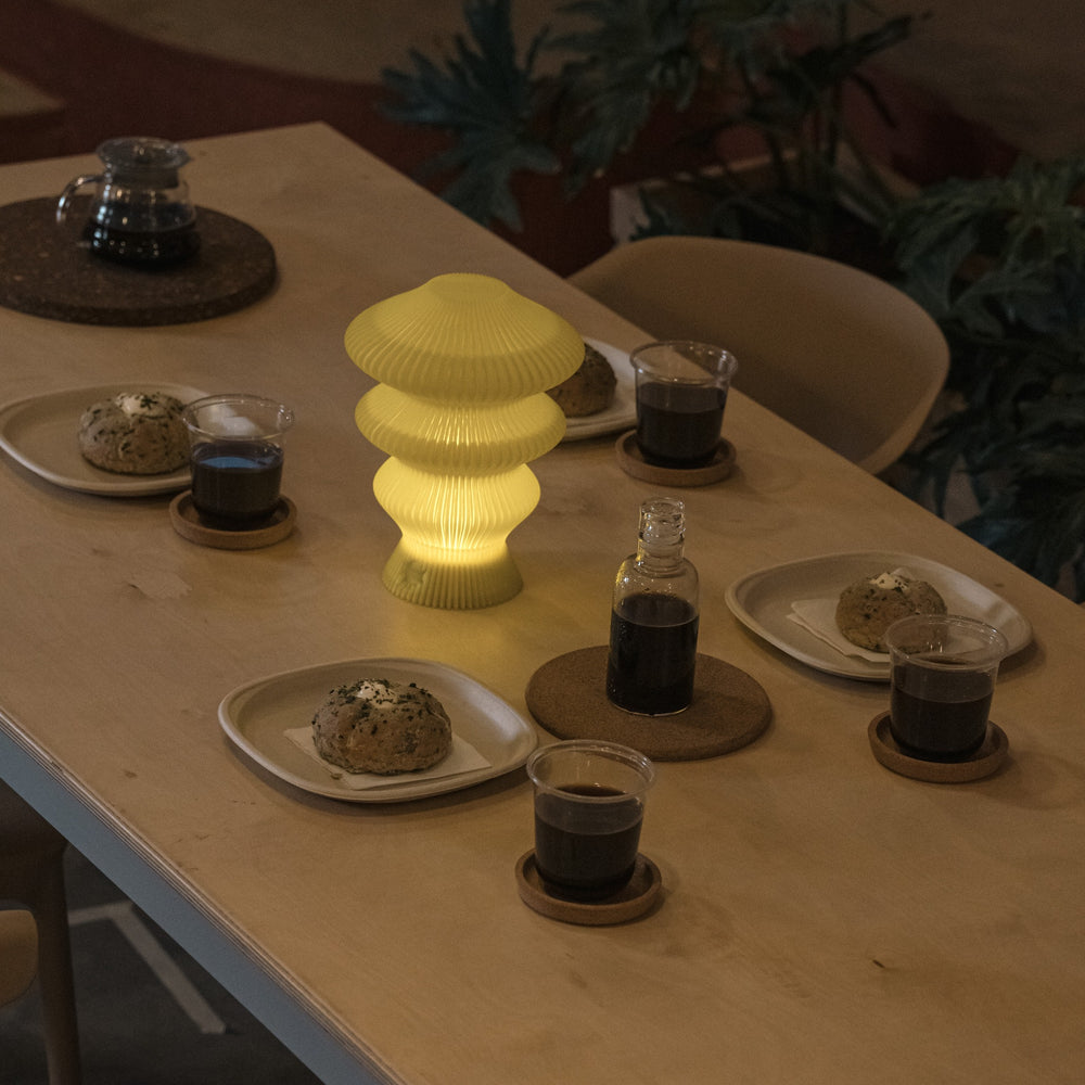 Yellow Ruvaa Mono rechargeable ambient table lamp glowing on a dining table