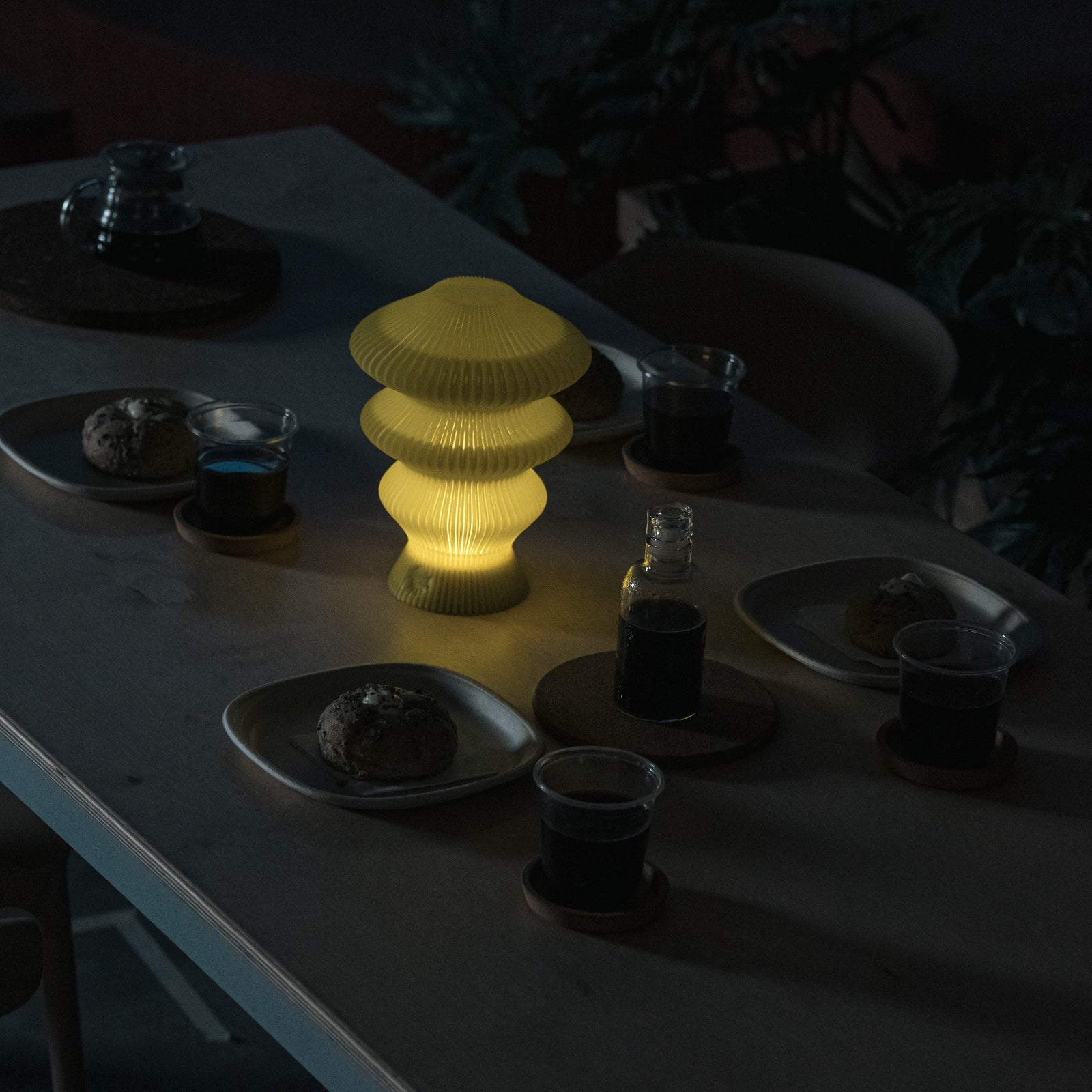 Yellow Ruvaa Mono touch ambient lamp illuminated in a dark dining setting